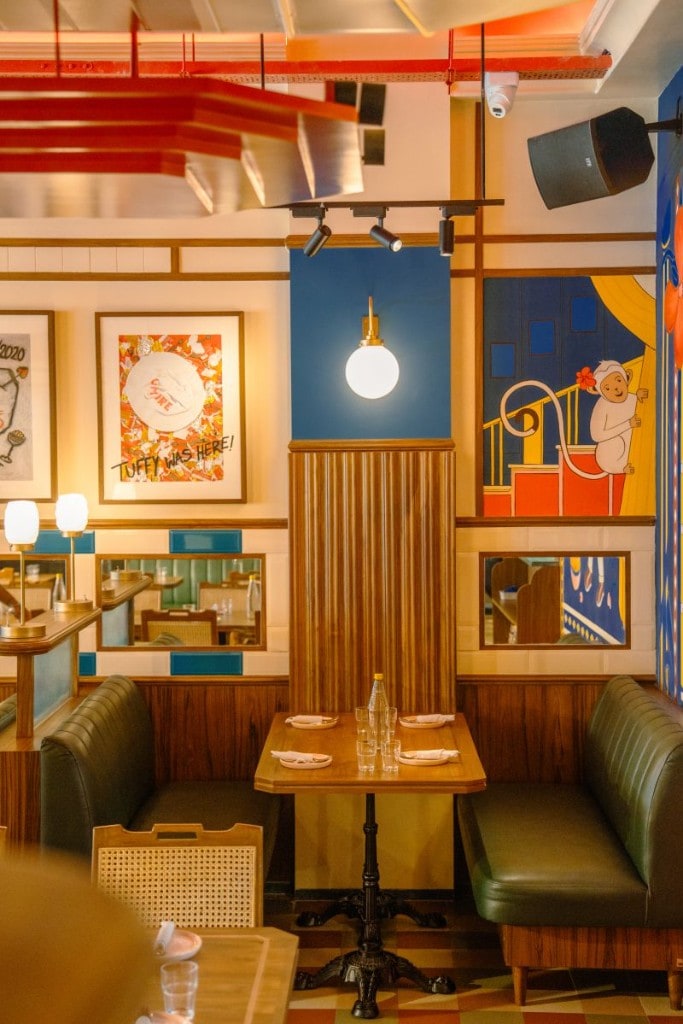 Booth seating with mirrored tile wall and monkey mural