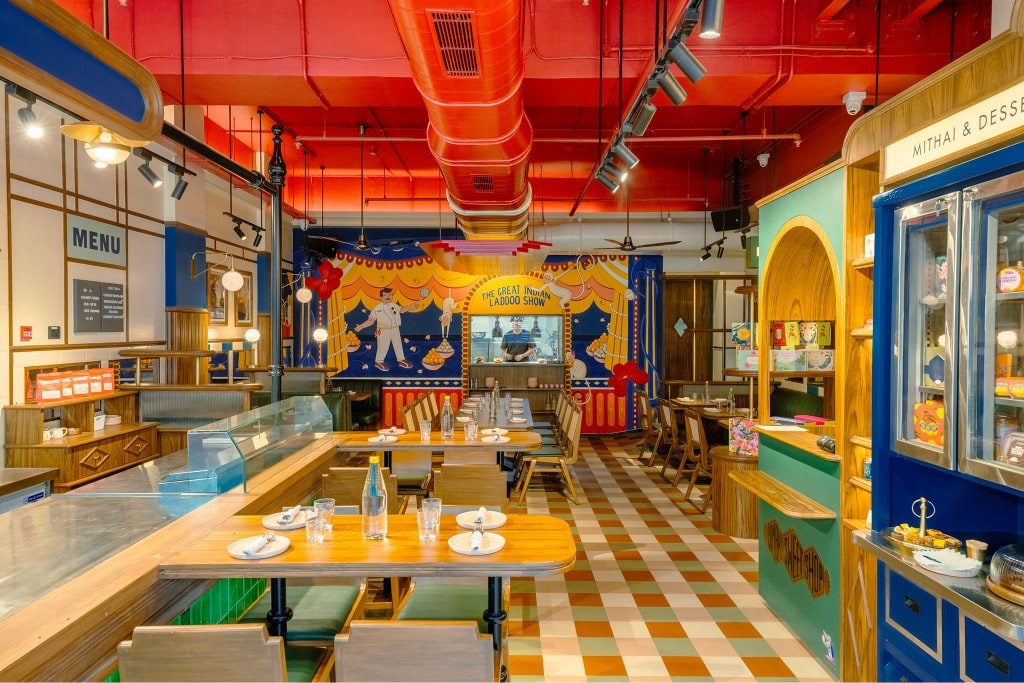 Great Indian Laddoo Show mural with dining tables and mithai display