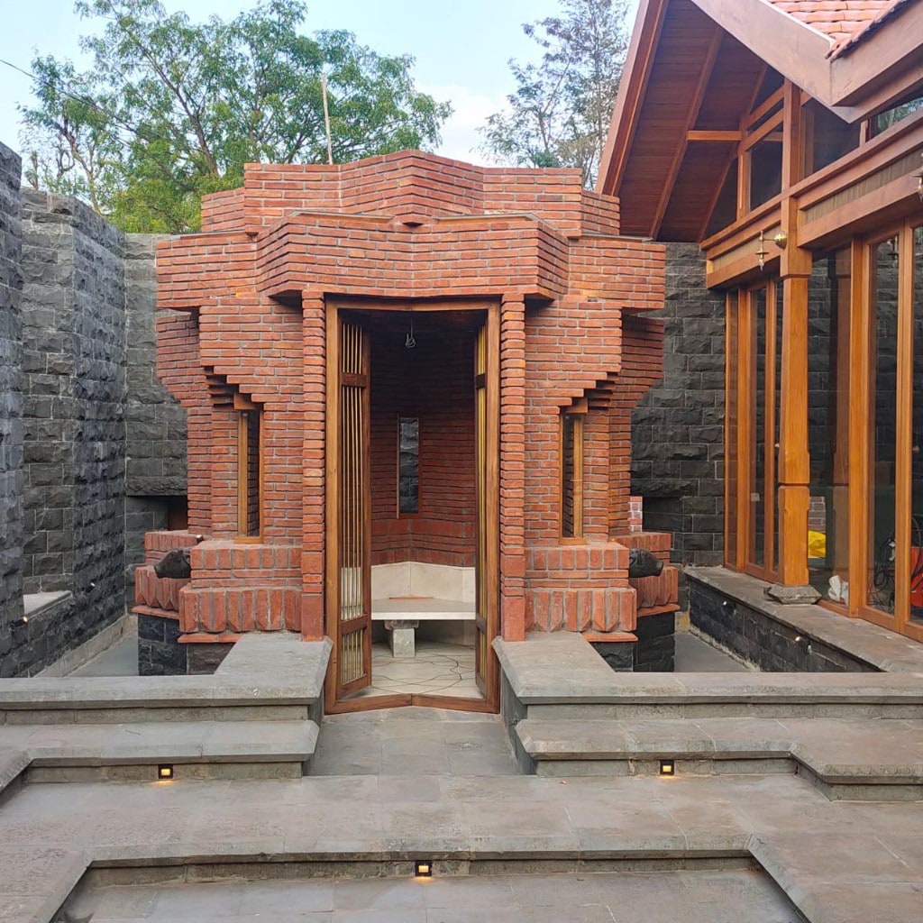 Brick pavilion with timber doors in stone courtyard