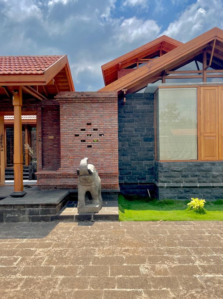 Brick jaali wall with elephant statue and gabled roofs